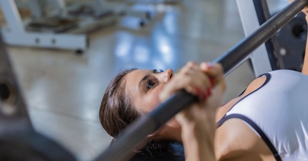 ベンチプレスをする女性