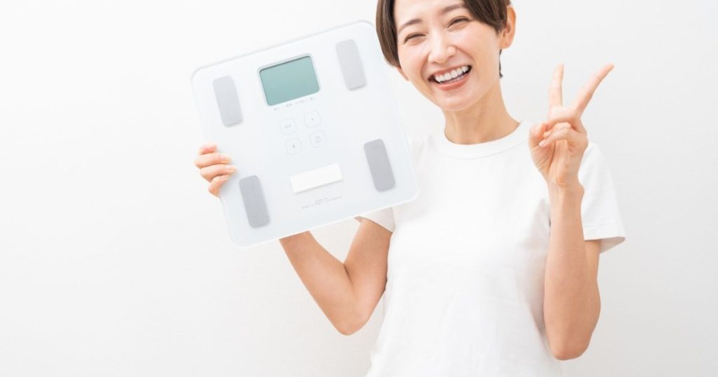 体重計を持つ女性